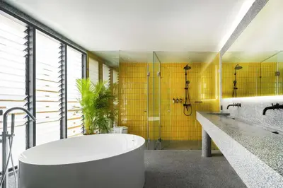 a bathroom with a tub and a yellow wall at Stupid Stay in Bangkok