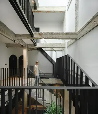 a person walking down the stairs of a building at Stupid Stay in Bangkok