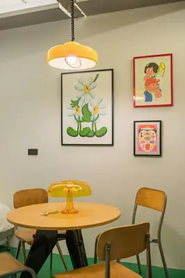 a table and chairs in a room with pictures on the wall at Stupid Stay in Bangkok
