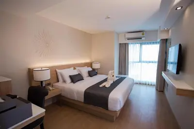 a hotel room with a large bed and a television at Iconic Hotel in Bangkok
