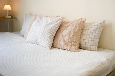 a bed with four pillows on top of it at 2BR, 6 Mins walk BTS Wuttakat in Bangkok