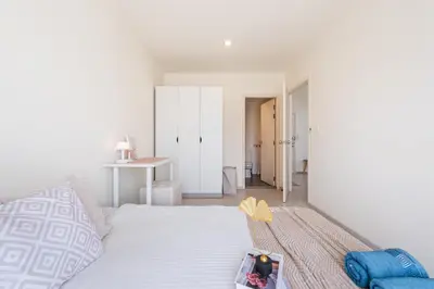 a bedroom with a bed and a table with an umbrella at 2BR, 6 Mins walk BTS Wuttakat in Bangkok