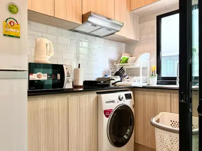 a kitchen with a washing machine in a kitchen at Free pick up and Stunning Luxury Family Home 2B2B in Bangkok