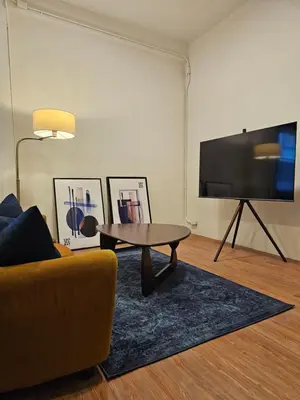 a living room with a couch and a table and a flat screen tv at Yaowarat Stay in Bangkok