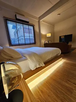 a bedroom with a large white bed with a window at Yaowarat Stay in Bangkok