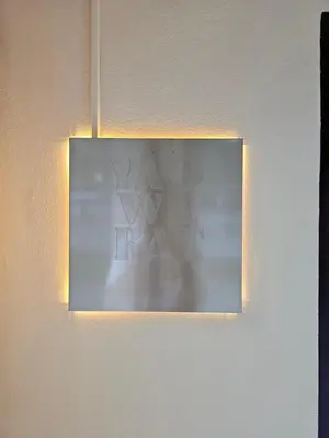 a mirror hanging on a wall with a light at Yaowarat Stay in Bangkok