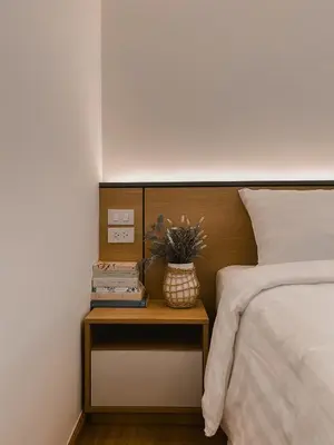 a side table with a plant on it next to a bed at Townhouse PK Garden in Bangkok