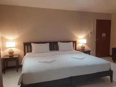 a bedroom with a large white bed with two lamps at Townhouse PK Garden in Bangkok