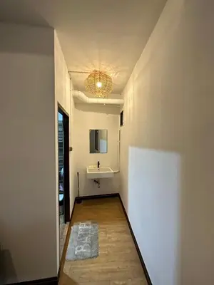 a hallway with a bathroom with a sink and a mirror at Thai Siwilai Hostel in Bangkok