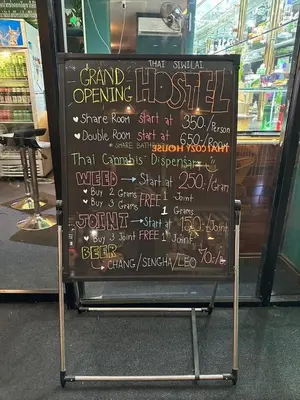 a chalkboard sign with writing on it in a store at Thai Siwilai Hostel in Bangkok