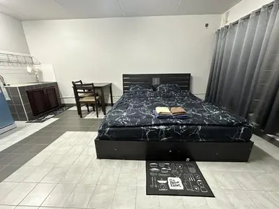 a bedroom with a bed with a black comforter at Muangthong p2 in Ban Song Hong