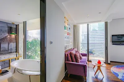 a bathroom with a tub and a couch in a room at Hotel Indigo Bangkok Wireless Road by IHG in Bangkok