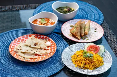a table with plates of food and bowls of food at Hotel Indigo Bangkok Wireless Road by IHG in Bangkok