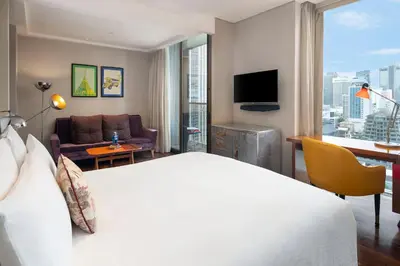 a hotel room with a bed and a living room at Hotel Indigo Bangkok Wireless Road by IHG in Bangkok