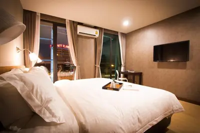 a hotel room with a bed and a television at C U Inn Bangkok in Bangkok