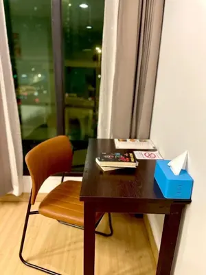 a wooden table with a chair and a desk with a book at C U Inn Bangkok in Bangkok