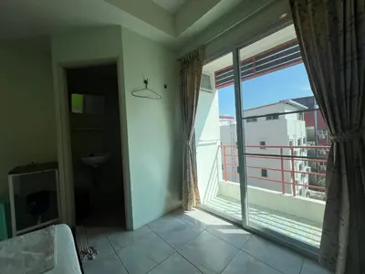 a bedroom with a large window with a view of a city at Bonita House in Bangkok