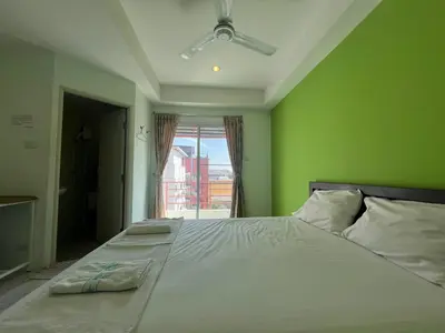 a bedroom with a large bed with a green wall at Bonita House in Bangkok