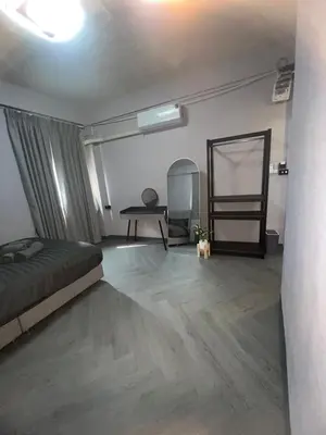a bedroom with a bed and a table and a mirror at Inntown in Amphoe Phra Khanong