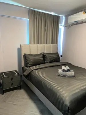 a bedroom with a large bed with a night stand at Inntown in Amphoe Phra Khanong