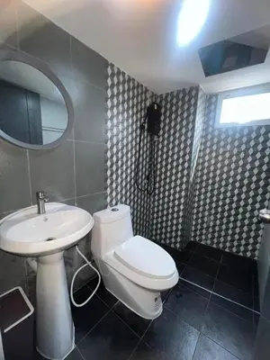 a bathroom with a toilet and a sink and a mirror at Inntown in Amphoe Phra Khanong