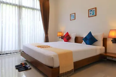 a bedroom with a large white bed with colorful pillows at The Choice Hotel - Adults Only in Bangkok