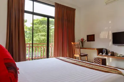 a hotel room with a bed and a balcony at The Choice Hotel - Adults Only in Bangkok