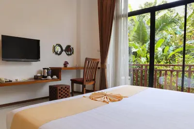 a bedroom with a bed and a balcony with a tv at The Choice Hotel - Adults Only in Bangkok