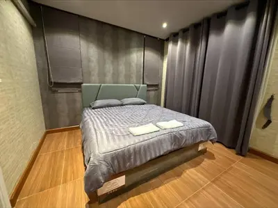 a bedroom with a bed with two towels on it at The Lake Guest House in Ban Bang Phang