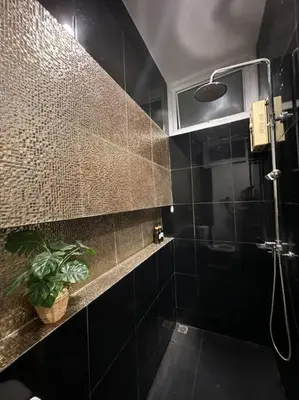 a black bathroom with a shower and a plant at The Lake Guest House in Ban Bang Phang