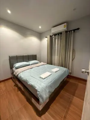 a bedroom with a bed with two towels on it at The Lake Guest House in Ban Bang Phang