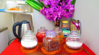 a table with jars of milk and a vase of flowers at Fall Asleep hotel in Nonthaburi