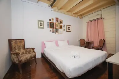 a bedroom with a large white bed and a chair at XX Mitr Inn Yaowarat - มิตร อินน์ เยาวราช in Khlong San