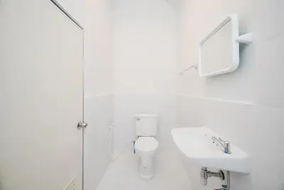 a white bathroom with a toilet and a sink at XX Mitr Inn Yaowarat - มิตร อินน์ เยาวราช in Khlong San