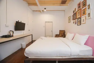 a bedroom with a large white bed and a desk at XX Mitr Inn Yaowarat - มิตร อินน์ เยาวราช in Khlong San