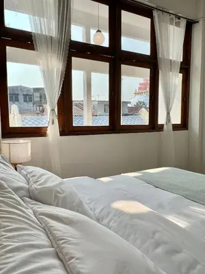 a bedroom with a bed and two windows at Sabay Home in Bangkok