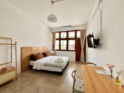 a bedroom with a bed and a desk and a table at Sabay Home in Bangkok