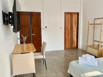 a room with a table and a chair and a table and a door at Sabay Home in Bangkok