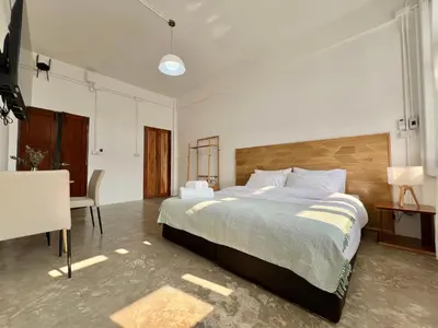 a bedroom with a large bed and a desk at Sabay Home in Bangkok