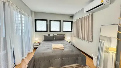 a large bed in a room with windows at FRIENDS@SaiLom in Bangkok