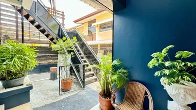 a balcony with potted plants and stairs in a building at FRIENDS@SaiLom in Bangkok