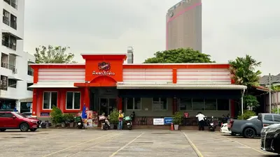 a red and white building in a parking lot at FRIENDS@SaiLom in Bangkok