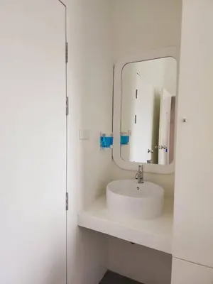 a white bathroom with a sink and a mirror at Line Bangkok Hostel in Bangkok