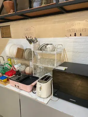 a kitchen counter with a microwave and some dishes at Brio Cafe and Hostel in Godown
