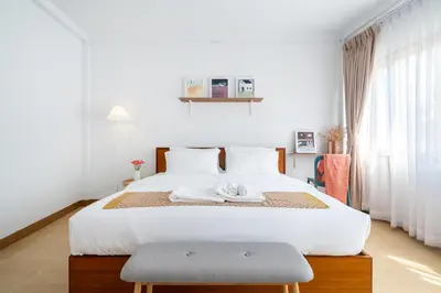 a bedroom with a large white bed with a towel on it at Chummy House Khaosan 10-Min, Peace Haven in Bangkok
