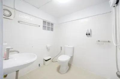 a white bathroom with a toilet and a sink at Chummy House Khaosan 10-Min, Peace Haven in Bangkok