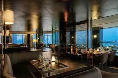 a restaurant with tables and chairs and a view of the city at Sathorn prime Panorama City View rooftop bar in Bangkok