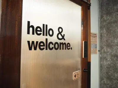 a door with a hello and welcome sign on it at Bed Space Hostel Khaosan in Bangkok