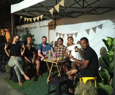 a group of people sitting at a table under a tent at Bed Space Hostel Khaosan in Bangkok