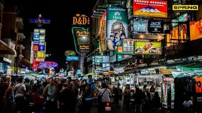 a crowd of people walking down a busy city street at night at Bed Space Hostel Khaosan in Bangkok